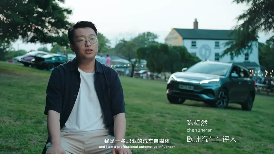 Interview subject standing beside an electric vehicle.